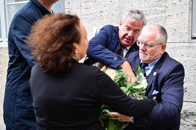 20 July 2026, Berlin: Tobias Korenke (C), a descendant of Nazi resistance fighters, stands near a dismantled Alternative for Germany (AfD) wreath during a federal memorial service at the Bendlerblock. Photo: Sebastian Christoph Gollnow/dpa