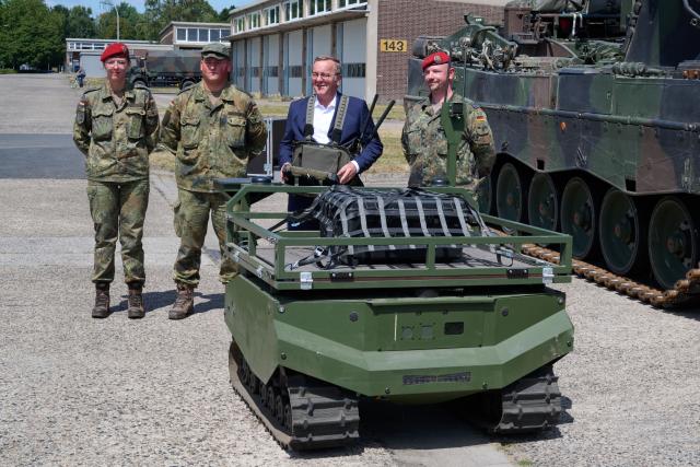 21 July 2026, North Rhine-Westphalia, Unna: German Minister of Defense Boris Pistorius (R) uses a remote control to operate the "Gereon" transport drone manufactured by "ARX Robotics" during a visit to Supply Battalion 7 at the Glueckauf Barracks. Photo: Bernd Thissen/dpa
