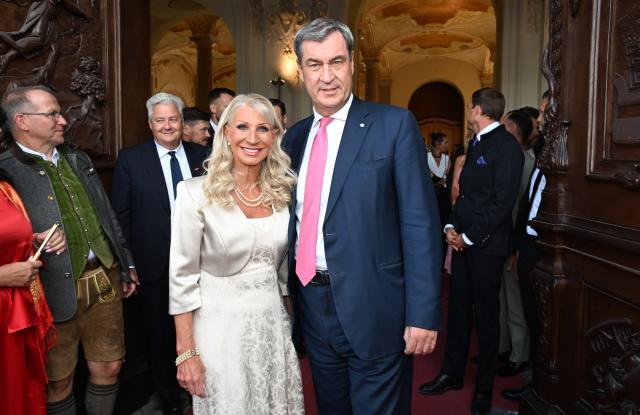 21 July 2026, Bavaria, Oberschleissheim: Bavarian Minister-President Markus Soeder and his wife, Karin Baumueller-Soeder, attend the Bavarian State Parliament's summer reception at the New Palace in Schleissheim. Photo: Felix Hörhager/dpa