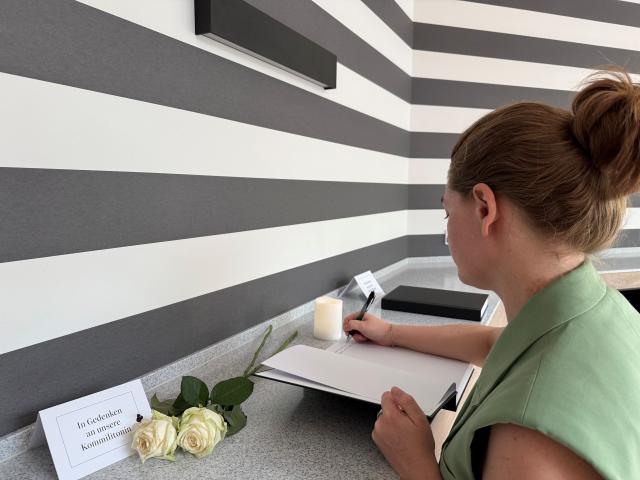 22 July 2026, Rhineland-Palatinate, Trier: A staff member at the University of Trier writes in the book of condolences for the murdered student. In recent days, two students at the University of Trier have been killed in violent incidents. Photo: Birgit Reichert/dpa