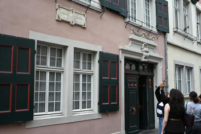 22 July 2026, North Rhine-Westphalia, Bonn: Tourists stand in front of the German composer and conductor Ludwig van Beethoven's House. Beethoven was born in this house in 1770. Photo: Wolf von Dewitz/dpa
