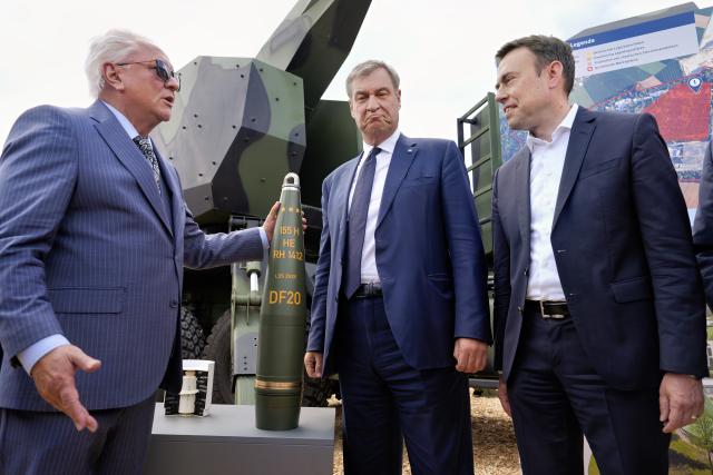 22 July 2026, Bavaria, Aschau A. Inn: (L-R) CEO of Rheinmetall AG Armin Papperger, Minister President of Bavaria Markus Soeder and Parliamentary State Secretary at the Ministry of Defense Nils Schmid view military exhibits produced by Rheinmetall AG during the groundbreaking ceremony for the company's powder plant. Photo: Uwe Lein/dpa