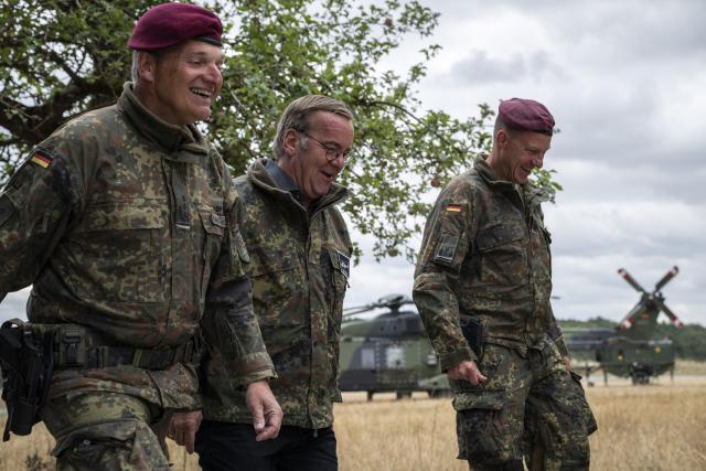 23 July 2026, Baden-Wuerttemberg, Hardheim: German Minister of Defense Boris Pistorius (C) leaves the landing pad accompanied by Colonel Roger Kahle-Specht (L), commander of Transport Helicopter Regiment 30 "Tauberfranken". Photo: Hannes P. Albert/dpa