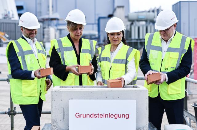 23 July 2026, North Rhine-Westphalia, Cologne: German Minister for Economic Affairs and Energy Katherina Reiche (2nd R), Mayor Torsten Burmester (R), Minister of Economic Affairs for North Rhine-Westphalia Mona Neubauer (2nd L) and CEO of Rheinenergie Andreas Feicht (L) lay the cornerstone during the groundbreaking ceremony for a river-water heat pump at Rheinenergie. Photo: Oliver Berg/dpa