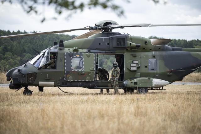 23 July 2026, Baden-Württemberg, Hardheim: The crew members of an NH90 helicopter stand in a field. German Defense Minister Pistorius (SPD) wants to get a firsthand look at the capabilities of the Army Aviation Group based in Niederstetten. According to the Defense Ministry, the group is establishing a helicopter task force for NATO. Photo: Hannes P. Albert/dpa