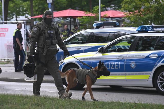 23 July 2026, Bavaria, Regensburg: A police officer is on duty with a police dog. A man was killed in a knife attack at a bank branch in Regensburg. Initially, the police had reported that a hostage situation was underway at the bank. Photo: Jason Tschepljakow/dpa