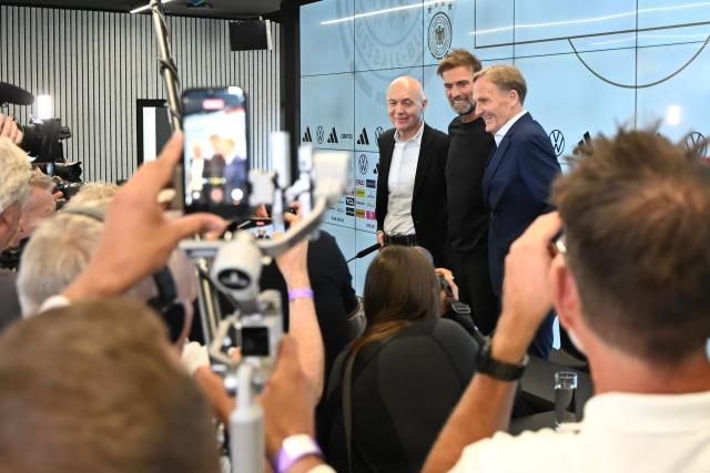 24 July 2026, Hesse, Frankfurt/Main: (L-R) Bernd Neuendorf, president of the German Football Association (DFB), Juergen Klopp and Hans-Joachim Watzke, DFB vice-president, stand on the podium at the start of a press conference to introduce the new national team head coach. Photo: Jennifer Brückner/dpa
