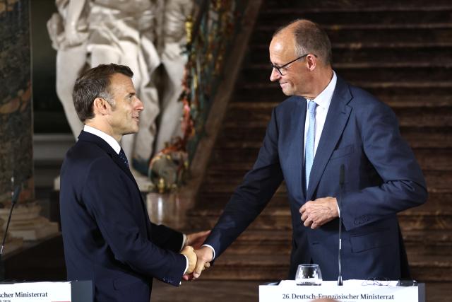 FILED - 17 July 2026, North Rhine-Westphalia, Bruehl: French President Emmanuel Macron and German Chancellor Friedrich Merz shake hands after a joint press conference, following a meeting of the Franco-German Ministerial Council, as part of intergovernmental consultations between the two countries, at Augustusburg Palace. Photo: Oliver Berg/dpa