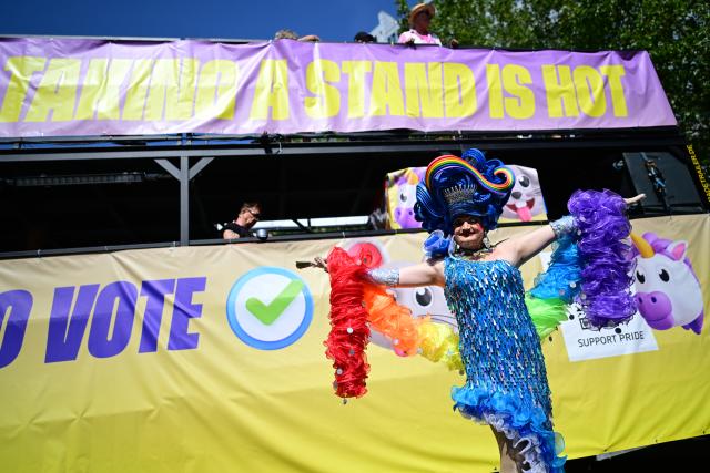 25 July 2026, Berlin: A person poses in front of a float as people march under the slogan "Attitude is Hot" during Christopher Street Day (CSD) in Berlin. For the first time, Berlin's CSD is taking place over two days. Photo: Fabian Sommer/dpa