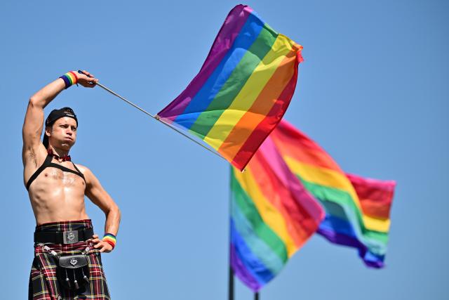 25 July 2026, Berlin: A participant dances in front of rainbow flags during Christopher Street Day (CSD) in Berlin, held under the slogan "Attitude Is Hot." For the first time, Berlin's CSD is taking place over two days. Photo: Sebastian Gollnow/dpa