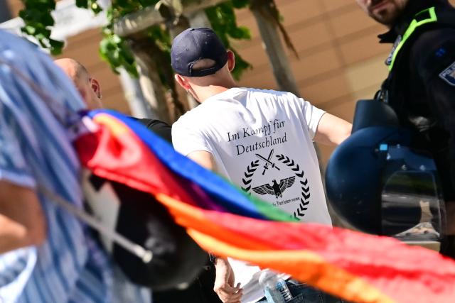 25 July 2026, Berlin: Far-right demonstrators are detained by police at Potsdamer Platz while on their way to a counter-demonstration against Christopher Street Day (CSD). The counter-demonstration is held under the slogan "We say 'No to CSD' - End the gender nonsense - There are only two genders: man and woman." Photo: Sebastian Gollnow/dpa