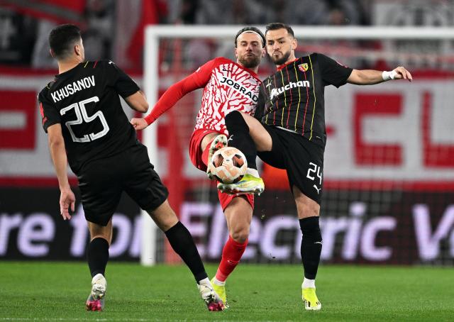 FILED - 22 February 2024, Baden-Wuerttemberg, Freiburg Im Breisgau: FILE PHOTO - Freiburg's Lucas Hoeler (C) in and Lens' Abdukodir Khusanov (L) and Jonathan Gradit battle for the ball during the UEFA Europa League soccer match between SC Freiburg and RC Lens at Europa-Park Stadium. Photo: Harry Langer/dpa