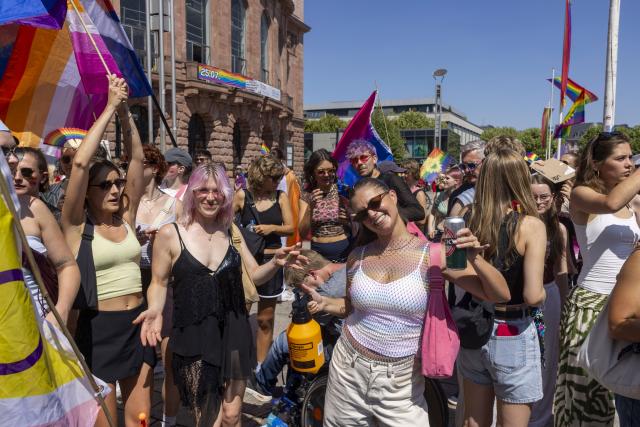 25 July 2026, Rhineland-Palatinate, Mainz: People take part in the Christopher Street Day (CSD) parade at the State Theater in front of Mainz Cathedral. The parade, which promotes diversity, tolerance, and queer rights, is traditionally organized by the Mainz-based association "Schwuguntia." Photo: Helmut Fricke/dpa