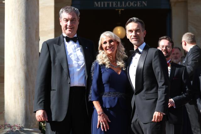 25 July 2026, Bavaria, Bayreuth: (L-R) Markus Soeder, Minister-President of Bavaria, his wife Karin Baumueller-Soeder, and Florian Silbereisen, show host and television presenter, arrive at the Festspielhaus for the opening of the Richard Wagner Festival. The Bayreuth Festival kicks off its 150th anniversary with Ludwig van Beethoven's Ninth Symphony. Photo: Karl-Josef Hildenbrand/dpa
