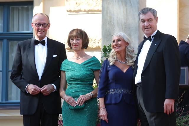25 July 2026, Bavaria, Bayreuth: German Chancellor Friedrich Merz (L), his wife Charlotte Merz (2nd L), Markus Soeder (R), Minister-President of Bavaria, and his wife Karin Baumueller-Soeder, arrive at the Festspielhaus for the opening of the Richard Wagner Festival. The Bayreuth Festival kicks off its 150th anniversary with Ludwig van Beethoven's Ninth Symphony. Photo: Karl-Josef Hildenbrand/dpa