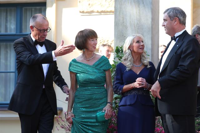 25 July 2026, Bavaria, Bayreuth: German Chancellor Friedrich Merz (L), his wife Charlotte Merz (2nd L), Markus Soeder (R), Minister-President of Bavaria, and his wife Karin Baumueller-Soeder, arrive at the Festspielhaus for the opening of the Richard Wagner Festival. The Bayreuth Festival kicks off its 150th anniversary with Ludwig van Beethoven's Ninth Symphony. Photo: Karl-Josef Hildenbrand/dpa