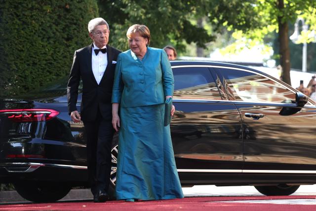 25 July 2026, Bavaria, Bayreuth: Former German Chancellor Angela Merkel (R) and her husband Joachim Sauer arrive at the Festspielhaus for the opening of the Richard Wagner Festival. The Bayreuth Festival kicks off its 150th anniversary with Ludwig van Beethoven's Ninth Symphony. Photo: Karl-Josef Hildenbrand/dpa