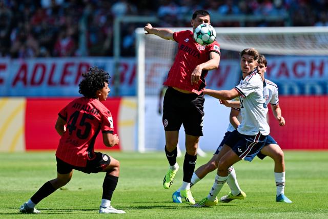25 July 2026, Hesse, Wiesbaden: (L-R) Wehen Wiesbaden's Ibrahim Ati Allah, Moritz Flotho, and Bayern Munich's Raphael Pavlic battle for the ball during the German Bundesliga Pre-season soccer match between SV Wehen Wiesbaden and FC Bayern Munich at BRITA Arena. Photo: Uwe Anspach/dpa - IMPORTANT NOTICE: Bundesliga and DFB regulations prohibit any use of photographs as image sequences and/or quasi-video.