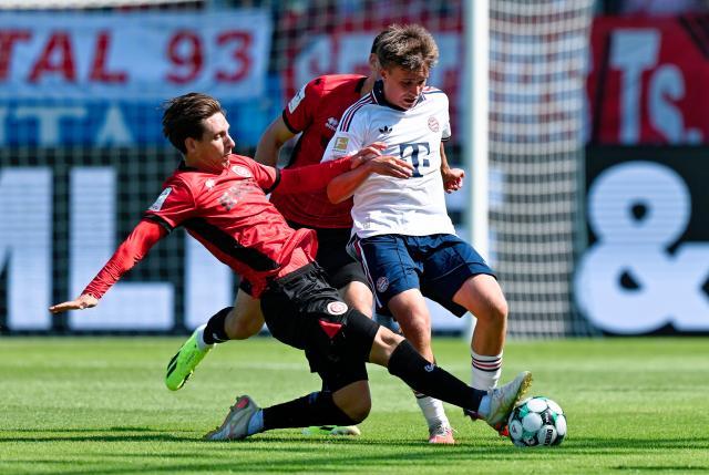 25 July 2026, Hesse, Wiesbaden: Wehen Wiesbaden's Max Brandt (L) and Bayern Munich's Simon Schaff battle for the ball during the German Bundesliga Pre-season soccer match between SV Wehen Wiesbaden and FC Bayern Munich at BRITA Arena. Photo: Uwe Anspach/dpa - IMPORTANT NOTICE: Bundesliga and DFB regulations prohibit any use of photographs as image sequences and/or quasi-video.