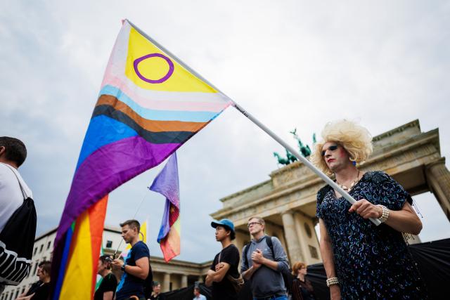 26 July 2026, Berlin: People take part in a demonstration in front of the Brandenburg Gate. Christopher Street Day in Berlin had been cut short the day before after a car plowed into a crowd on the outskirts of the large-scale event. Photo: Christoph Soeder/dpa