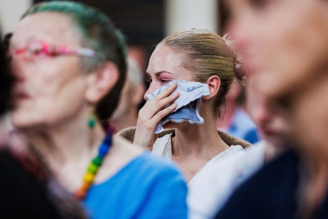 26 July 2026, Berlin: A woman wipes her face with a handkerchief during the service at St. Mary's Church after a vehicle had driven into a crowd of people on the sidelines of Christopher Street Day in Berlin. Photo: Christoph Soeder/dpa