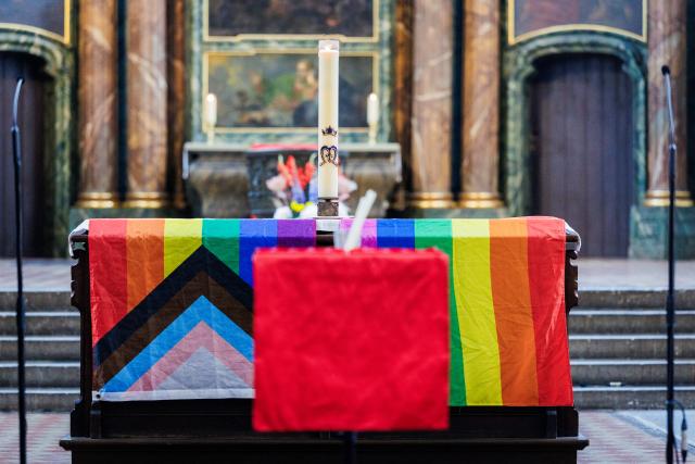 26 July 2026, Berlin: A rainbow flag and a Progress Pride flag lie on the altar inside St. Mary's Church after a vehicle had driven into a crowd of people on the sidelines of Christopher Street Day in Berlin. Photo: Christoph Soeder/dpa