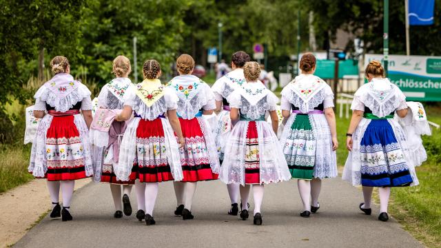 26 July 2026, Brandenburg, Burg: Young women in Sorbian/Wendish traditional costumes walk to the event venue before the start of the traditional Sorbian-Wendish "rooster plucking" contest at the harvest festival in the Spreewald. Photo: Frank Hammerschmidt/dpa