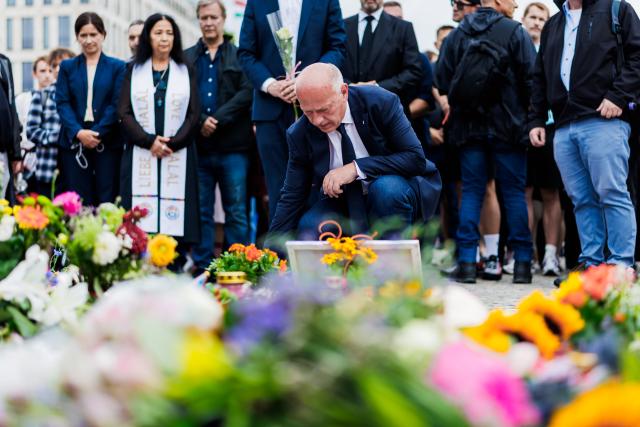 26 July 2026, Berlin: Governing Mayor of Berlin Kai Wegner (C) lays flowers during a memorial service held at the site in Tiergarten where a car had plowed into a crowd on the sidelines of Christopher Street Day (CSD). Photo: Christoph Soeder/dpa