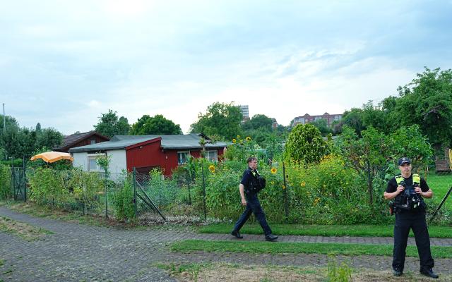 26 July 2026, Berlin: Police officers stand on the scene at an allotment garden community in Berlin-Spandau. According to information from security sources, one person was killed during a police operation in Spandau following the terrorist attack on the sidelines of Christopher Street Day (CSD). Photo: Michael Kappeler/dpa