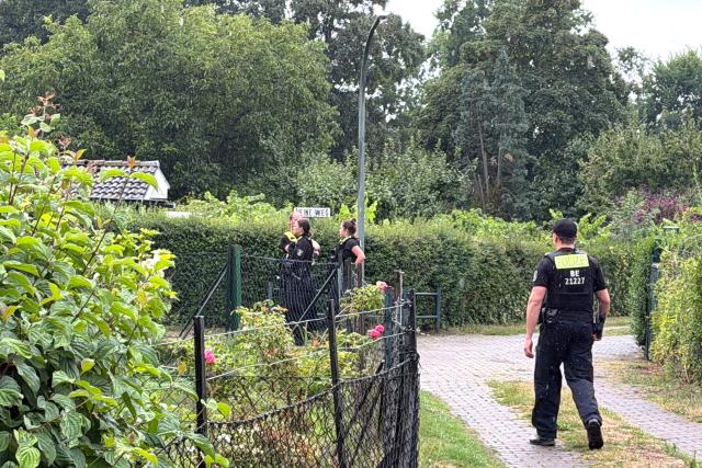 26 July 2026, Berlin: Police officers stand on the scene at an allotment garden community in Berlin-Spandau. According to information from security sources, one person was killed during a police operation in Spandau following the terrorist attack on the sidelines of Christopher Street Day (CSD). Photo: Verena Schmitt-Roschmann/dpa