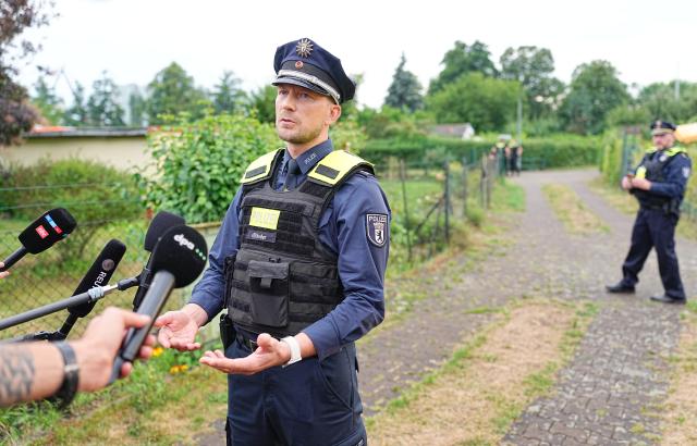26 July 2026, Berlin: Joern Ifflaender, deputy press secretary for the Berlin Police, makes a statement at an allotment garden colony in Berlin-Spandau. According to information from security sources, one person was killed during a police operation in Spandau following the terrorist attack on the sidelines of Christopher Street Day (CSD). Photo: Michael Kappeler/dpa