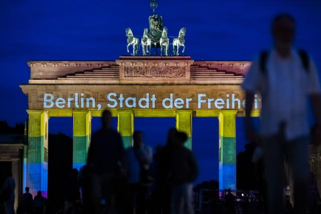 26 July 2026, Berlin: The Brandenburg Gate is illuminated in rainbow colors, displaying the words "Berlin, City of Freedom". Christopher Street Day in Berlin had been cut short the day before after a car plowed into a crowd on the outskirts of the large-scale event. Photo: Christoph Soeder/dpa