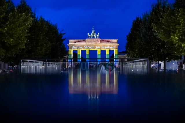 26 July 2026, Berlin: The Brandenburg Gate is illuminated in rainbow colors, displaying the words "Berlin, City of Freedom". Christopher Street Day in Berlin had been cut short the day before after a car plowed into a crowd on the outskirts of the large-scale event. Photo: Christoph Soeder/dpa