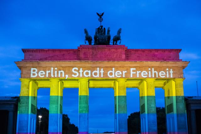 26 July 2026, Berlin: The Brandenburg Gate is illuminated in rainbow colors, displaying the words "Berlin, City of Freedom". Christopher Street Day in Berlin had been cut short the day before after a car plowed into a crowd on the outskirts of the large-scale event. Photo: Christoph Soeder/dpa
