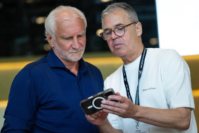 27 July 2026, Rhineland-Palatinate, Mainz: Andreas Rettig (R), Director of Sports for the German Football Association (DFB), shows Rudi Voeller, the DFB's Director of Sports, something on his cell phone during the International Coaches' Congress. Photo: Florian Wiegand/dpa