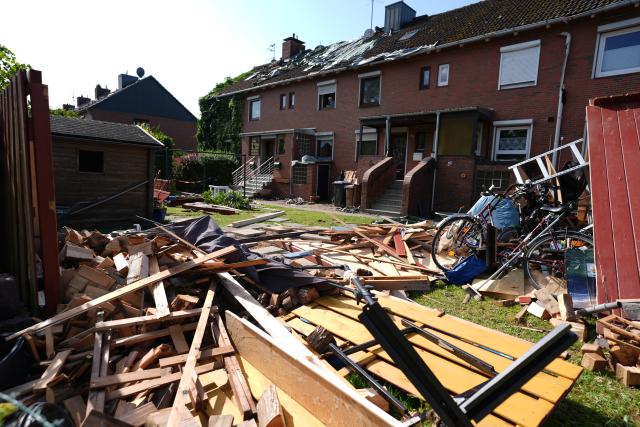 27 July 2026, Schleswig-Holstein, Glückstadt: Temporary tarps covering the roof of a damaged townhouse in Glueckstadt. A suspected tornado left a trail of destruction across the region, destroying roofs and power lines, with initial police estimates putting the total damage at a six- to seven-figure sum Photo: Marcus Brandt/dpa