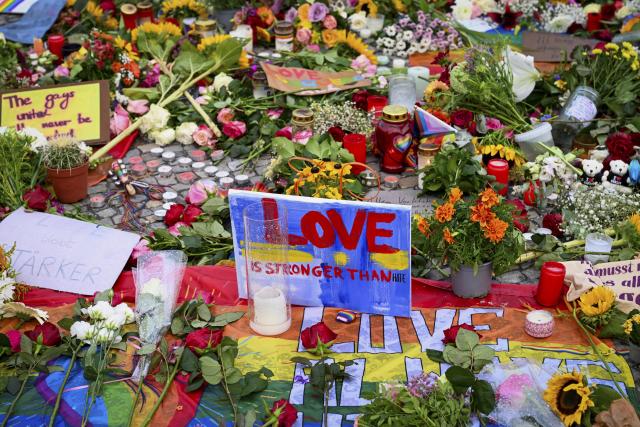 27 July 2026, Berlin: Flowers, candles, messages, and a rainbow flag can be seen on Pariser Platz in front of the Brandenburg Gate, following the terrorist attack on the sidelines of Christopher Street Day (CSD) after a car plowed into a crowd. Photo: Soeren Stache/dpa