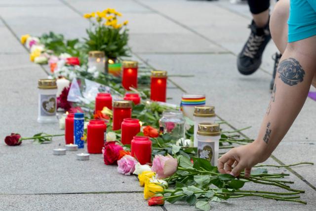 27 July 2026, Saxony, Dresden: A woman lays flowers at the vigil held by Queer Pride Dresden and other groups in response to the terrorist attack on the sidelines of Christopher Street Day (CSD) in Berlin. Photo: Daniel Wagner/dpa