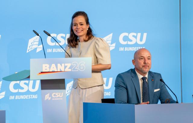 28 July 2026, Bavaria, Bad Staffelstein: Bonita Grupp (L), managing partner of Trigema W. Grupp KG, takes the podium at Banz Abbey. Seated next to her is Alexander Hoffmann (R), chairman of the CSU parliamentary group in the Bundestag, during the final day of the group's summer retreat. Photo: Daniel Vogl/dpa