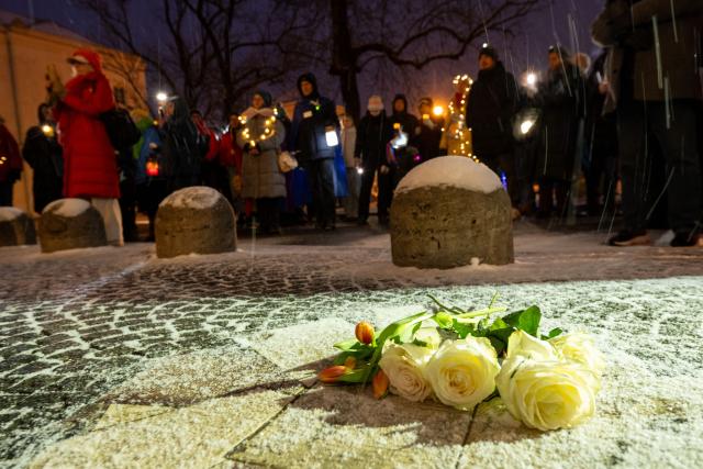 FILED - 16 February 2025, Bavaria, Munich: FILE PHOTO - White roses and tulips lie on the ground, while men and women shine lights-including flashlights, smartphones, string lights, and other sources of light-at Geschwister-Scholl-Platz in Munich. Under the slogan "Never Again Is Now," numerous people commemoratE the victims of the attack on February 13, 2025, when a car plowed into a ver.di demonstration. Photo: Pia Bayer/dpa