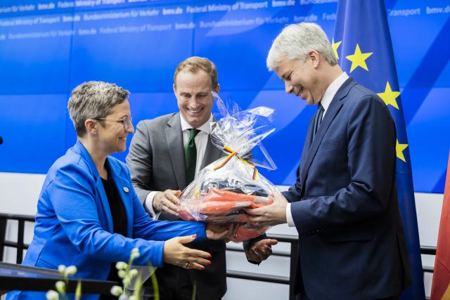 29 July 2026, Berlin: (L-R) New German Transport Minister Steffen Bilger accepts a welcome gift from Christian Motzer of the Protocol Office and Claudia Stutz, State Secretary at the Federal Ministry of Transport, during the handover ceremony at the Federal Ministry of Transport (BMV). Photo: Christoph Soeder/dpa