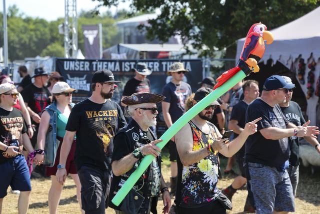 29 July 2026, Schleswig-Holstein, Wacken: Festivalgoers are lining up at an entrance to the Wacken Open Air (W:O:A). The W:O:A is considered the world's largest heavy metal festival. Photo: Frank Molter/dpa
