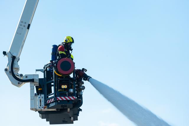 29 July 2026, Saarland, Neunkirchen: A firefighter conducts mop-up operations at an industrial building in the Wellesweiler district. Several people were injured in a major fire at a recycling facility for spray cans and similar pressurized containers. Photo: Laszlo Pinter/dpa