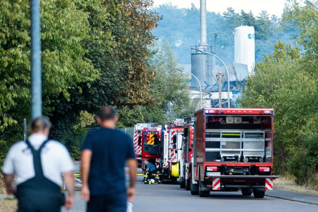 29 July 2026, Saarland, Neunkirchen: Fire department emergency vehicles are on the scene for follow-up firefighting operations at an industrial building in the Wellesweiler district. Several people were injured in a major fire at a recycling facility for spray cans and similar pressurized containers. Photo: Laszlo Pinter/dpa