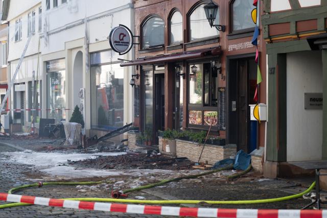 30 July 2026, Hesse, Lauterbach (Hessen): Firefighters conduct mop-up operations, after a major blaze severely damaged several historic half-timbered houses. Initial estimates by the local fire department indicate the incident in the central German state of Hesse caused at least five million euros in property damage. Photo: Florian Wiegand/dpa