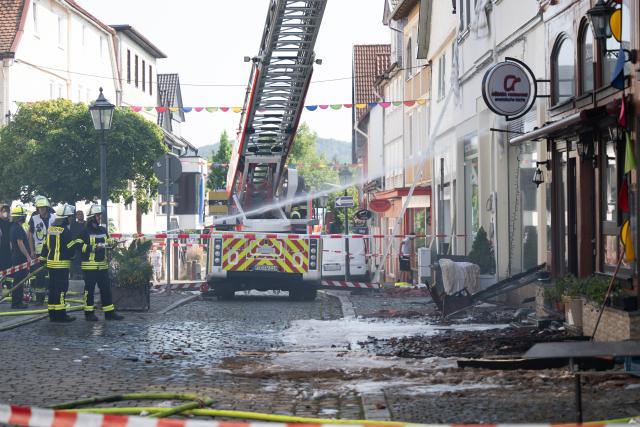 30 July 2026, Hesse, Lauterbach (Hessen): Firefighters conduct mop-up operations, after a major blaze severely damaged several historic half-timbered houses. Initial estimates by the local fire department indicate the incident in the central German state of Hesse caused at least five million euros in property damage. Photo: Florian Wiegand/dpa