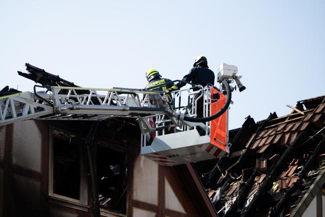 30 July 2026, Hesse, Lauterbach (Hessen): Firefighters conduct mop-up operations, after a major blaze severely damaged several historic half-timbered houses. Initial estimates by the local fire department indicate the incident in the central German state of Hesse caused at least five million euros in property damage. Photo: Florian Wiegand/dpa