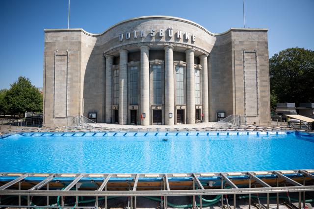 30 July 2026, Berlin: A view shows a newly installed 25-meter-long temporary swimming pool in front of the Volksbuehne theater on Rosa-Luxemburg-Platz. Incoming artistic director Matthias Lilienthal commissioned the pool to mark the start of his tenure, with the installation scheduled to run from August through October. The facility is currently closed to the public ahead of its official seasonal opening. Photo: Sebastian Christoph Gollnow/dpa