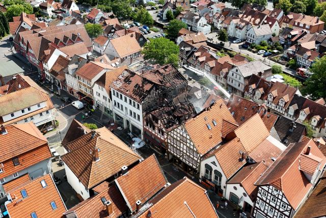 30 July 2026, Hesse, Lauterbach (Hessen): An aerial drone view shows firefighters conducting mop-up operations, after a major blaze damaged several half-timbered houses. Initial estimates by the local fire department indicate that the fire in the central German state of Hesse caused at least five million euros in property. Photo: Florian Wiegand/dpa