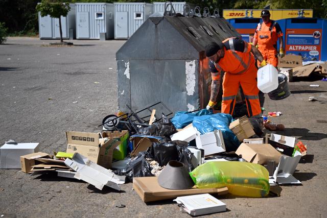 30 July 2026, North Rhine-Westphalia, Bonn: Employees of the local waste management municipal enterprise bonnOrange clear away illegally dumped garbage. The city is deploying specialized "trash detectives" to investigate illegal waste sites and track down perpetrators, a growing problem affecting municipalities across the western German state of North Rhine-Westphalia. Photo: Federico Gambarini/dpa